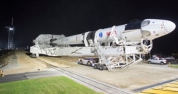 In this Monday, Nov. 9, 2020 photo provided by NASA, a SpaceX Falcon 9 rocket and Crew Dragon capsule is rolled out of the horizontal integration facility at Launch Complex 39A, as preparations continue for a crewed mission at NASA's Kennedy Space Center