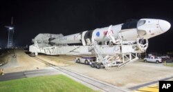 In this Monday, Nov. 9, 2020 photo provided by NASA, a SpaceX Falcon 9 rocket and Crew Dragon capsule is rolled out of the horizontal integration facility at Launch Complex 39A, as preparations continue for a crewed mission at NASA's Kennedy Space Center