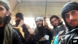 This May 7, 2014 photo provided by the anti-government activist group Coordination Committee of Khalidiya Neighborhood in Homs, which has been authenticated based on its contents and other AP reporting, shows Free Syrian Army fighters on a bus 