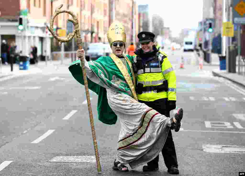 A man dressed as St. Patrick stops for a picture with an Irish police officer, as people gather for the yearly St. Patrick&#39;s Day parade through the city center of Dublin, Ireland, on March 17, 2019.