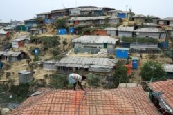 A Rohingya refugee repairs the roof of his shelter at the Balukhali refugee camp in Cox's Bazar, Bangladesh, March 5, 2019.