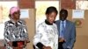 Zimbabwe's President Robert Mugabe (R) and his wife Grace (L) look on as their daughter Bona casts her vote in Highfields outside Harare July 31, 2013. Zimbabweans voted in large numbers on Wednesday in a fiercely contested election pitting veteran Presid