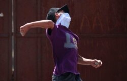 A protester throws a stone towards Indian police during a protest after the funeral of Asrar Ahmed Khan, who recently died after being injured during a protest on Aug. 6, 2019, in Srinagar, Sept. 4, 2019.