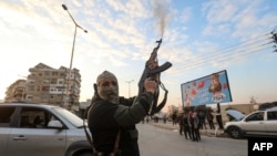 A Syrian anti-government fighter fires his rifle into the air in the streets of the west-central city of Hama on Dec. 5, 2024. 