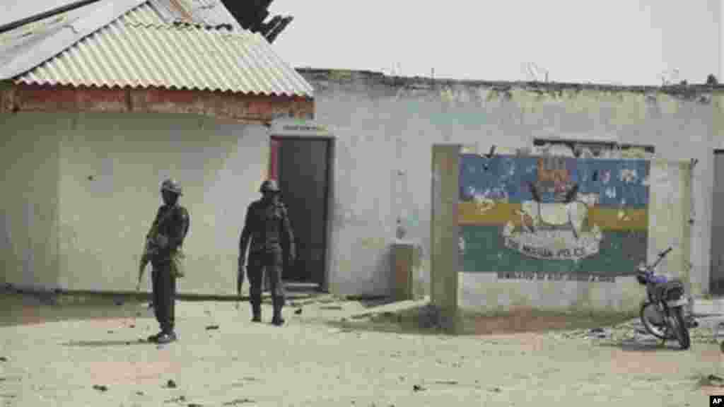 Police officers stand in front of the burned-out police station in Marte, Nigeria.
