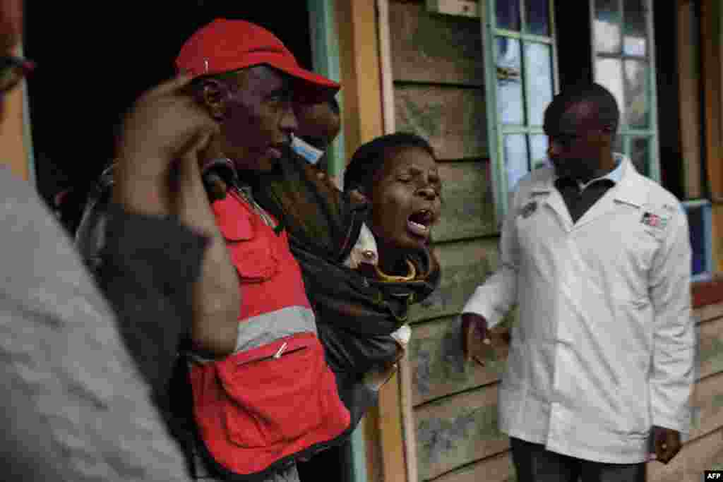 A woman reacts after visiting the burned dorm room at the Hillside Endarasha Academy in Nyeri county, Kenya, after a fire broke out, killing 17 children.