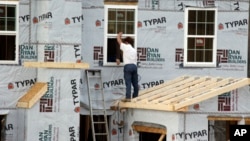 FILE - A worker continues construction on a housing complex in Zelienople, Pennsylvania, March 28, 2014.