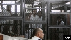 Bị cáo bị giam trong lồng trong phiên tòa xét xử 20 người, trong đó có 5 phóng viên của đài al-Jazeera,ngày 3 tháng 5, 2014.