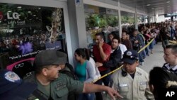 Largas filas se forman al frente de los supermercados para conseguir los productos básicos.