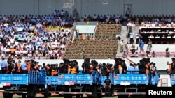 Trucks carrying criminals and suspects are seen during a mass sentencing rally at a stadium in Yili, Xinjiang, Uighur Autonomous Region, May 27, 2014.