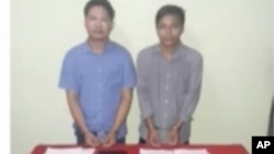 In this image released by the Myanmar Ministry of Information and broadcast by Myanmar's MRTV, on Dec. 13, 2017, Reuters reporters Wa Lone, left, and Kyaw Soe Oo stand handcuffed in Myanmar.
