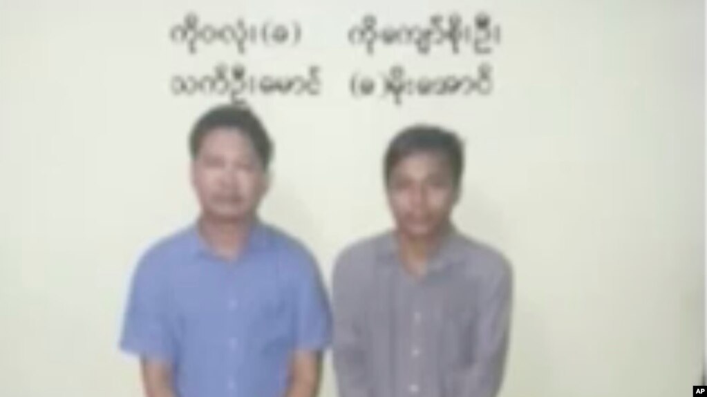 In this image released by the Myanmar Ministry of Information and broadcast by Myanmar's MRTV, on Dec. 13, 2017, Reuters reporters Wa Lone, left, and Kyaw Soe Oo stand handcuffed in Myanmar.