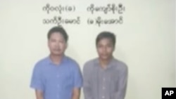 In this image released by the Myanmar Ministry of Information and broadcast by Myanmar's MRTV, on Dec. 13, 2017, Reuters reporters Wa Lone, left, and Kyaw Soe Oo stand handcuffed in Myanmar.