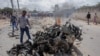 Agentes de segurança verificam os destroços da viatura que explodiu, Mogadíscio, 10 de Julho, 2021.