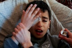 FILE - Palestinian boy Mohammad An-Najjar, 12, who was wounded in his eye during a protest at the Israel-Gaza border fence, reacts in pain inside his family house, in Khan Younis, in the southern Gaza Strip, Jan. 17, 2019.