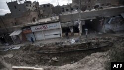 Hiện trường sau một vụ pháo kích của chính phủ Syria tại thành phố miền đông Deir Ezzor, ngày 16/2/2013. 