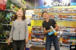 A brother and sister check out the latest gadgets at the International Toy Fair, in New York, Feb. 17, 2018.