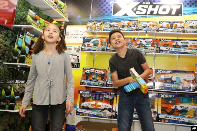 A brother and sister check out the latest gadgets at the International Toy Fair, in New York, Feb. 17, 2018.