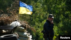 A Ukrainian serviceman smokes at a checkpoint near the town of Horlivka, Donetsk region, in eastern Ukraine, Sept. 18, 2014.