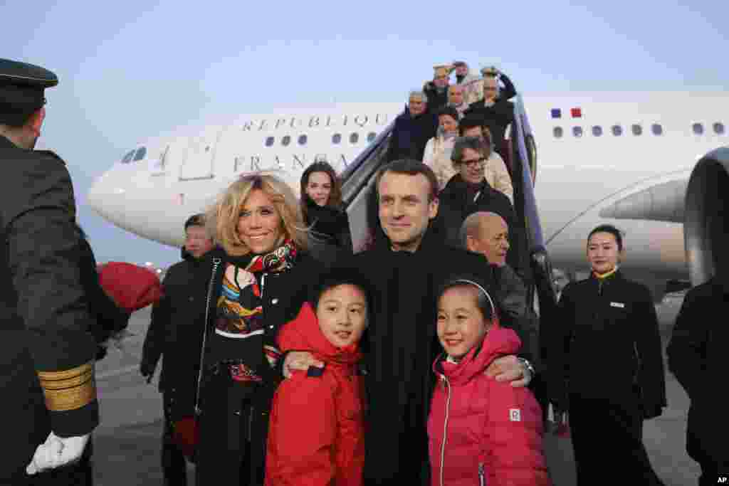 2018年1月8日，法国总统马克龙（Emmanuel Macron）和夫人布丽吉特&middot;马克龙（Brigitte Macron）在北京首都机场的停机坪和参加欢迎仪式的中国儿童合影。