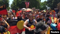 People carry Australian Aboriginal flags during a demonstration on Australia Day in Sydney, Jan. 26, 2019.