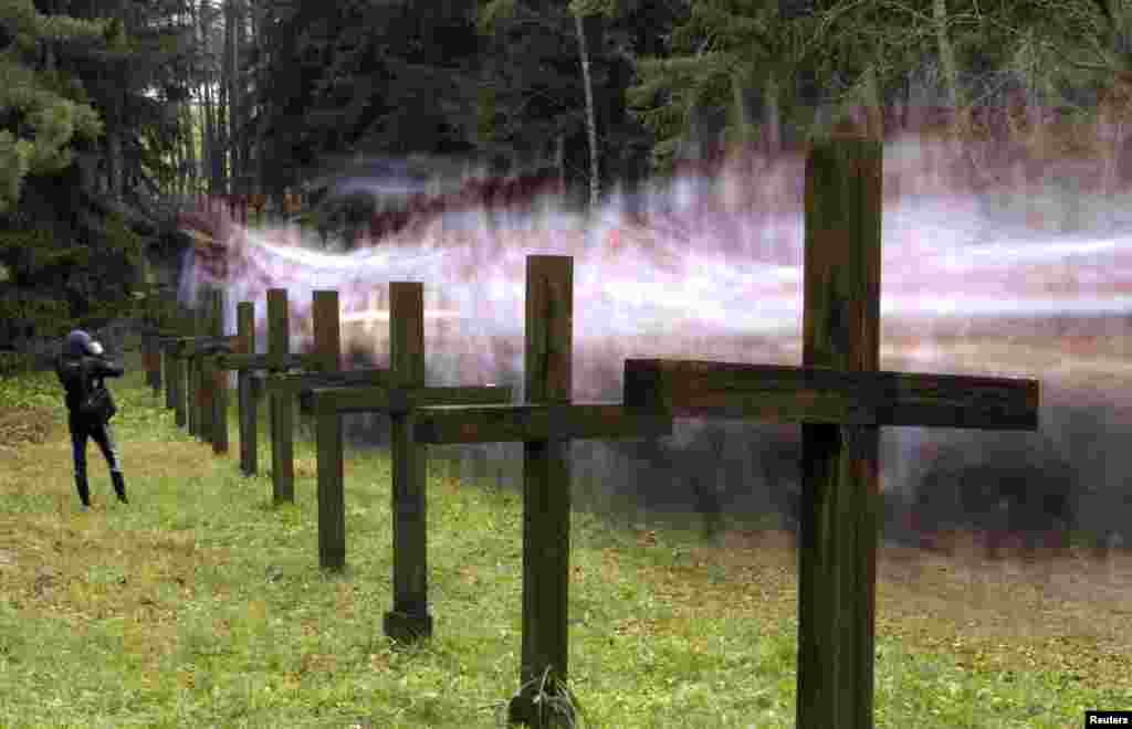 People walk among crosses at a mass grave in Kuropaty to commemorate the victims of Soviet dictator Joseph Stalin's regime, on the outskirts of Minsk, Belarus. 