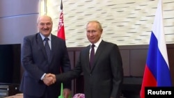 FILE - Russia's President Vladimir Putin shakes hands with his Belarusian counterpart Alexander Lukashenko during a meeting in Sochi, Russia, Sept. 14, 2020, in this still image taken from a video.