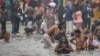 Hindu pilgrims take a dip in the sacred waters of Sangam, the confluence of Ganges, Yamuna and mythical Saraswati rivers during the Maha Kumbh Mela festival in Prayagraj on Jan. 13, 2025.