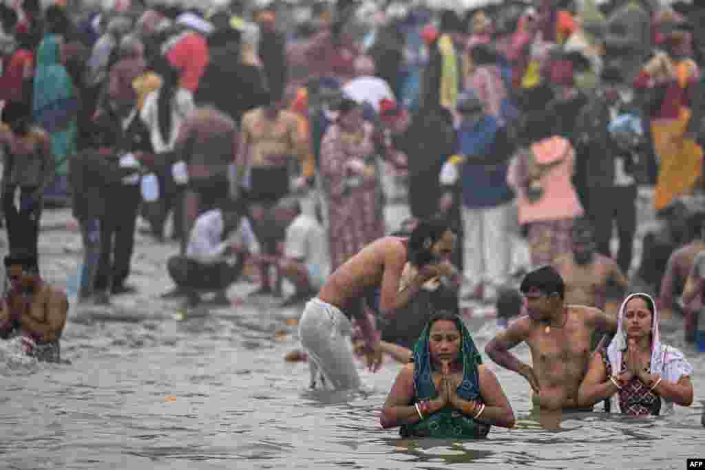 Hindu pilgrims take a dip in the sacred waters of Sangam, the confluence of Ganges, Yamuna and mythical Saraswati rivers during the Maha Kumbh Mela festival in Prayagraj on Jan. 13, 2025.