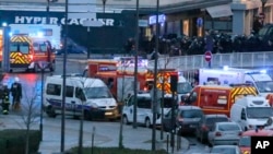 Police officers storm the kosher grocery store where a gunman held several hostages, in Paris, Jan. 9, 2015. 