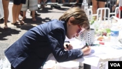 A boy writes a note of solidarity for the victims of Thursday's attack that killed 84 people and wounded over 200 in Nice, France, July 16, 2016. (H.Murdock/VOA)