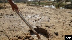 Water seeps through a hole in the ground in Libya's coastal city of Zliten, 150 kilometres east of the capital on February 13, 2024, as a result of rising groundwater levels. (Photo by Mahmud Turkia / AFP)