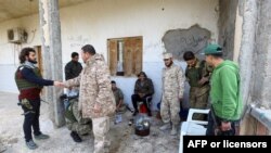 Para kombatan yang setia kepada pemerintah Libya yang diakui oleh internasional, GNA, beristirahat di sebuah tempat di selatan Ibu Kota Libya, Tripoli, 12 Januari 2020. Pihak-pihak yang bertikai di Libya setuju untuk gencatan senjata.