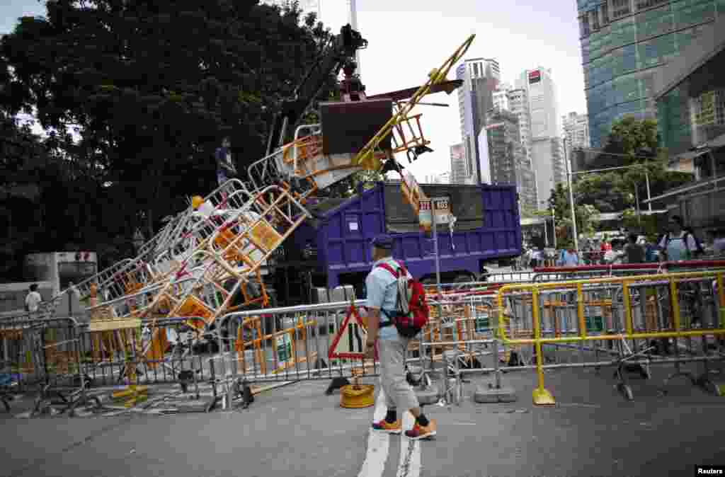 A crane removes barricades from the main protest site in the Admiralty district, near the government headquarters, in Hong Kong, Oct. 13, 2014. 