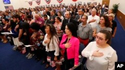 Citizen candidates recite the Pledge of Allegiance during a naturalization ceremony at the U.S. Citizenship and Immigration Services Miami field office, Friday, Aug. 16, 2019, in Miami. (AP)