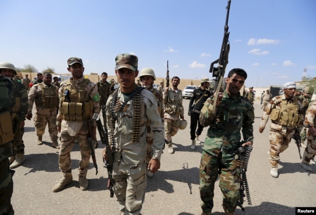 FILE - Iran-backed forces allied with Iraqi forces in Ouja, on the southern outskirts of Tikrit, March 26, 2015. The U.S. conditioned its entry into Iraq's battle to retake Tikrit from IS on the withdrawal of Shiite militias from the clearing operation.