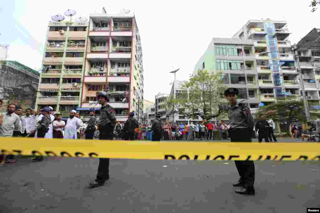 Police stand near a mosque and school dormitory that were damaged by a fire in Rangoon, Burma, April 2, 2013.