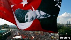 An anti-government protester waves a Turkish flag depicting the founder of modern Turkey Mustafa Kemal Ataturk as thousands of protesters gather in Istanbul's Taksim square, June 9, 2013.