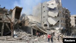 Warga memeriksa sebuah bangunan yang hancur akibat serangan udara di dekat kota Aleppo, Suriah (27/8). 