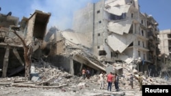 Những người đàn ông kiểm tra một căn nhà đổ nát sau một cuộc không kích trong vùng quân nổi dậy kiểm soát tại Aleppo, Syria, ngày 27 tháng 08 năm 2016. 