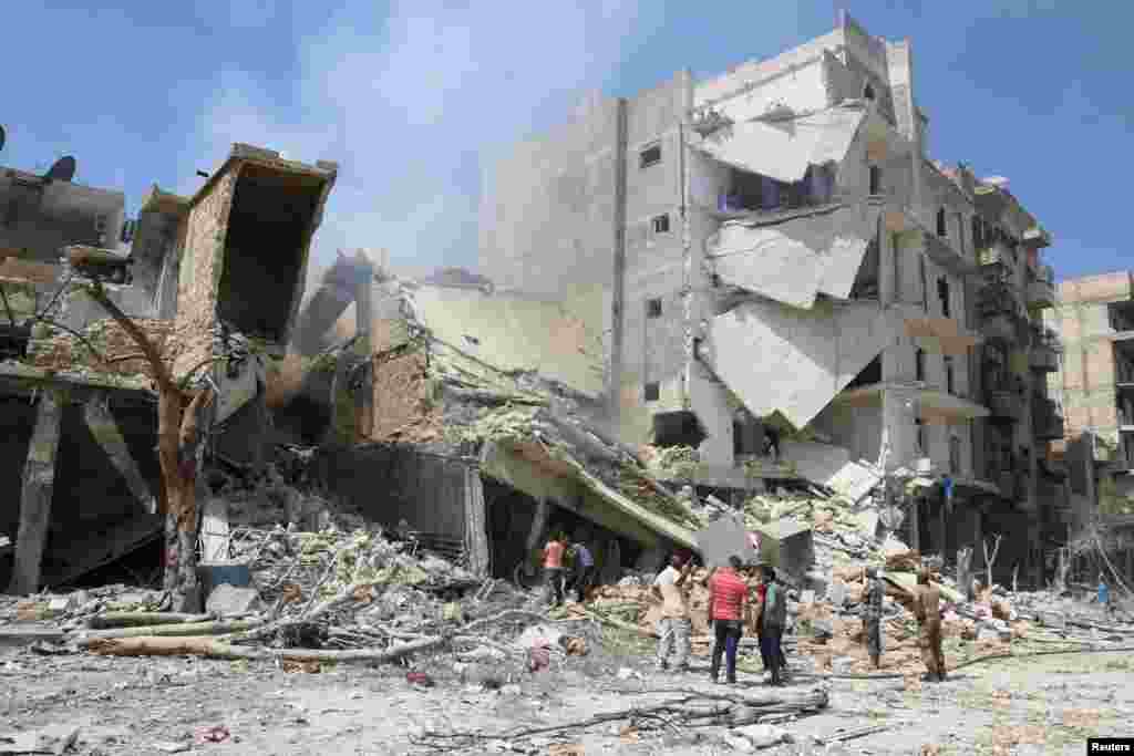 Men inspect a damaged building after airstrikes on a rebel-held neighborhood of Aleppo, Syria, Aug. 27, 2016.