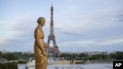 A statue wears a mask to encourage people to protect themselves against the spread of the coronavirus along the Trocadero square close to the Eiffel Tower Saturday, May 2, 2020, in Paris. France continues to be under an extended stay-at-home order until M