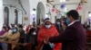 Seorang perempuan membersihkan tangannya sebelum menerima komuni di Gereja St Stephen saat perayaan Natal di kawasan lama Delhi, India, 25 Desember 2020. (Foto: REUTERS/Anushree Fadnavis)