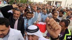 Bahraini anti-government protesters chant slogans as they move the body of Redha Buhameed who was killed by the Army during a protest on Friday, at a hospital in Manama, Feb 21 2011