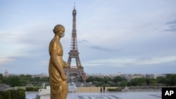 A statue wears a mask to encourage people to protect themselves against the spread of the coronavirus along the Trocadero square close to the Eiffel Tower Saturday, May 2, 2020, in Paris. France continues to be under an extended stay-at-home order until M