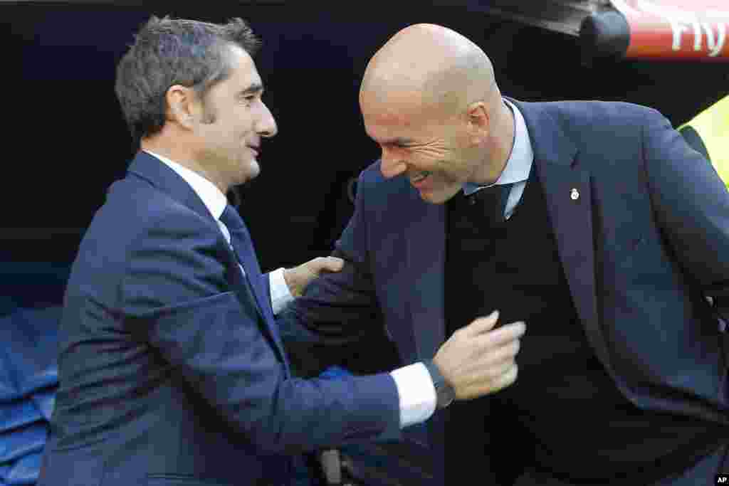 L&#39;entraîneur du Barcelona, Ernesto Valverde, et l&#39;entraîneur du Real Madrid Zinedine Zidane se saluent avant le début du match de football La Liga entre le Real Madrid et le Barcelone au stade Santiago Bernabeu de Madrid, le 23 décembre 2017.