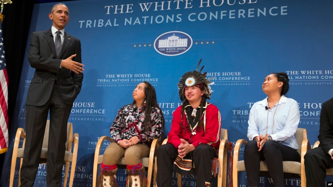 President Barack Obama speaks as, from left, Tatiana Ticknor of the Yup'ik/Tlingit/Dena'ina, Brayden White of the St. Regis Mohawk Tribe and Blossom Johnson of the Navajo Nation listen during the 2015 White House Tribal Nations Conference, Nov. 5, 2015.
