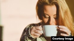 Woman waking up and drinking coffee.