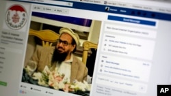 A photo shows a Facebook site that features one of India’s most wanted, Hafiz Saeed, the founder of Lashkar-e-Taiba, a banned organization and a U.S. declared terrorist group, in Islamabad, Pakistan, July 7, 2017. A senior Pakistani government official says more than 40 of 65 organizations banned in Pakistan operate flourishing social media sites, communicating on Facebook, Twitter, WhatsApp and Telegram to recruit, raise money and demand a rigid Islamic system. Meanwhile Pakistan is waging a cyber war against activists and journalists who use social media to criticize the government and its agencies.