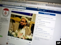 FILE - A photo shows a Facebook site that features one of India’s most wanted, Hafiz Saeed, the founder of Lashkar-e-Taiba, a banned organization and a U.S. declared terrorist group, in Islamabad, Pakistan, July 7, 2017.